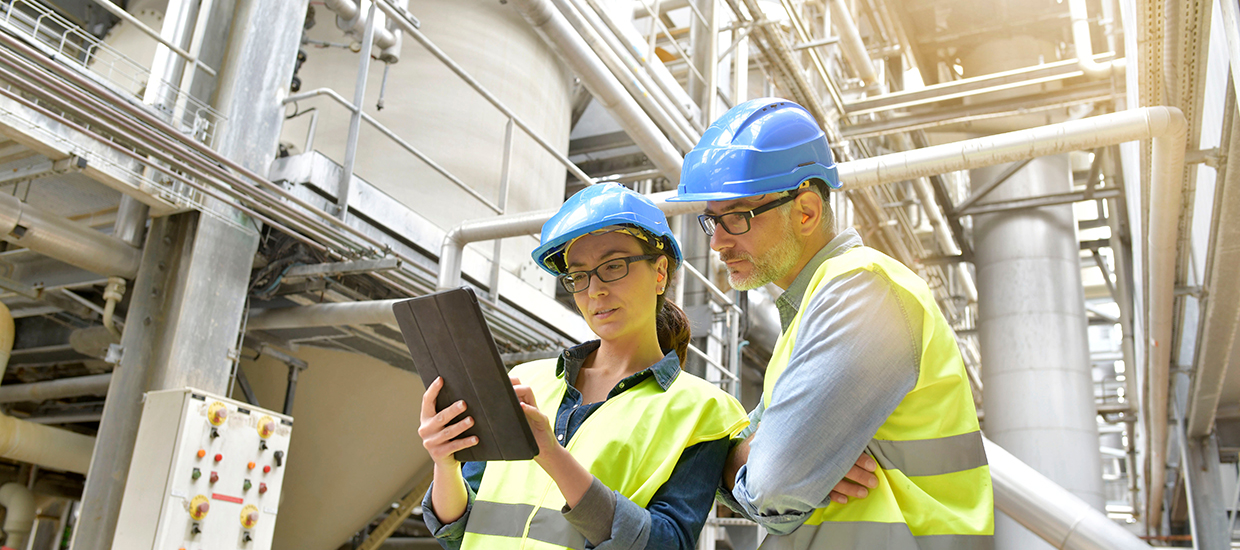 Industrial workers looking at a report in a factory. 