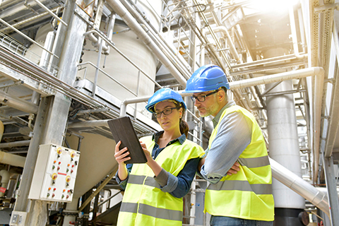 Industrial workers looking at a report in a factory. 