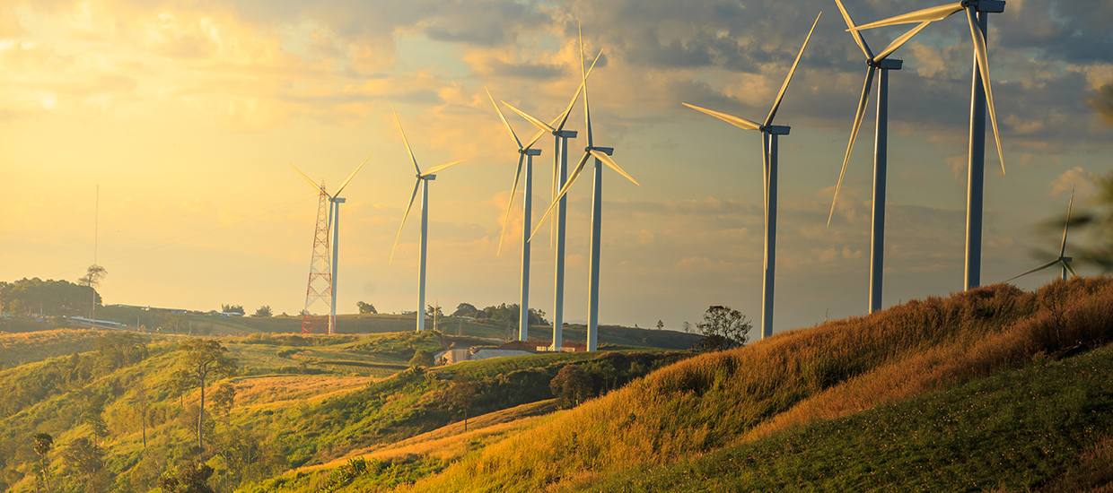 Sunset sinking over the hills of a wind turbine farm. 